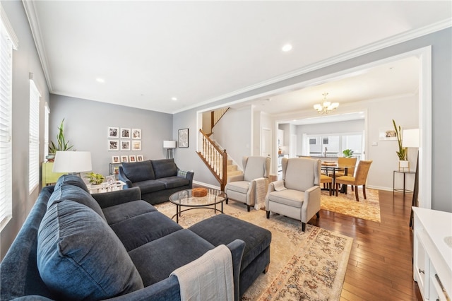 living room featuring hardwood / wood-style flooring, an inviting chandelier, and crown molding