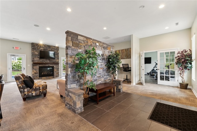 living room with a stone fireplace and tile patterned floors