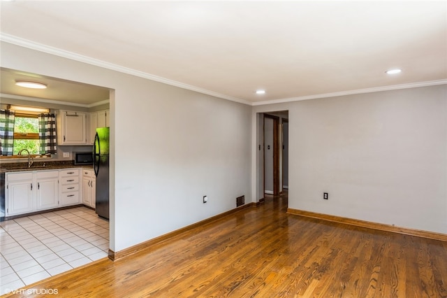 tiled spare room with sink and crown molding