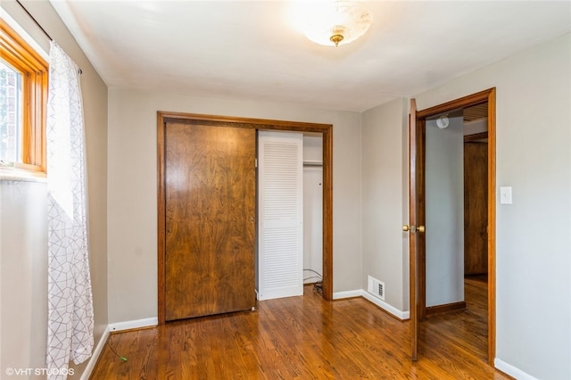 unfurnished bedroom with wood-type flooring and a closet