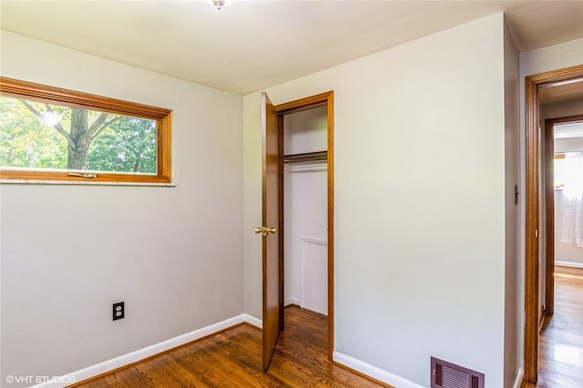 unfurnished bedroom featuring hardwood / wood-style flooring and a closet