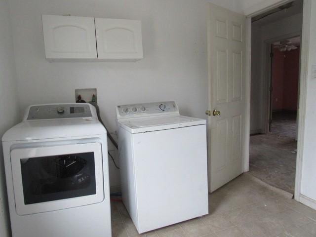 clothes washing area with washer and dryer and cabinet space