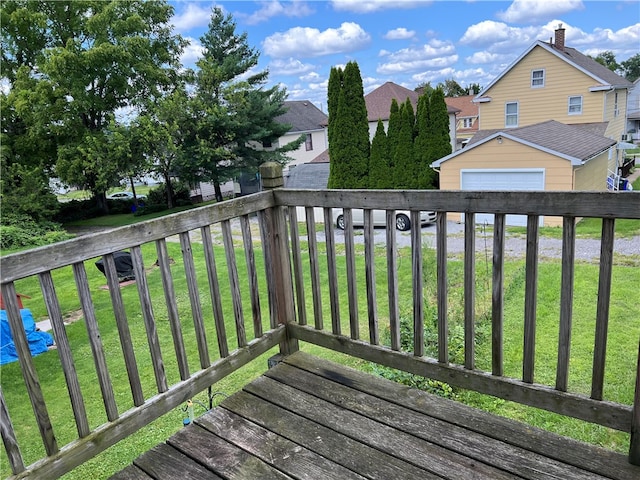 wooden deck featuring a garage and a yard