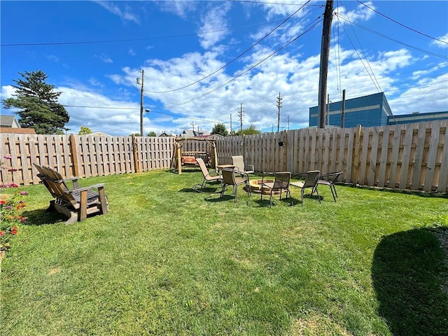 view of yard featuring a fenced backyard and a fire pit