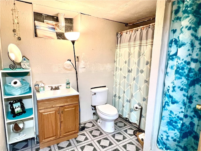 bathroom featuring a textured ceiling, vanity, toilet, and a shower with shower curtain