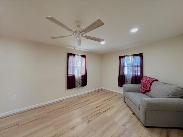 sitting room with light wood finished floors, recessed lighting, a ceiling fan, and baseboards