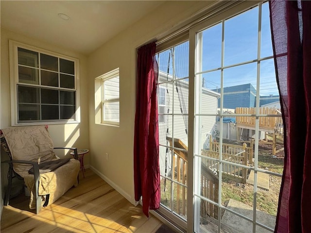 doorway to outside featuring baseboards and wood finished floors