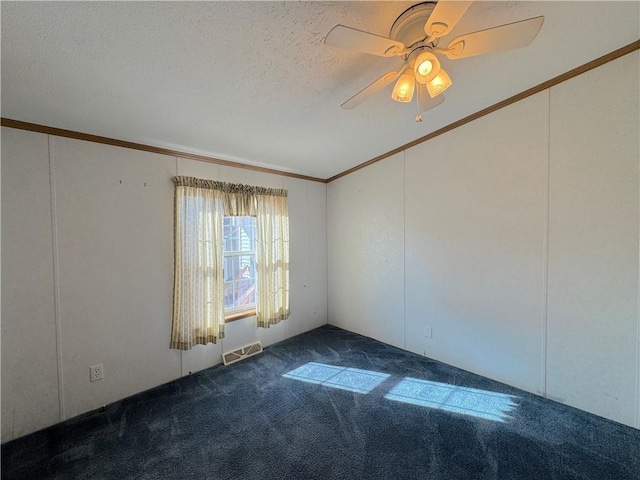 spare room featuring a textured ceiling, a ceiling fan, visible vents, dark carpet, and crown molding