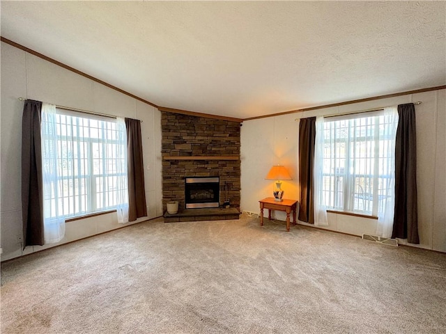 unfurnished living room with ornamental molding, lofted ceiling, a fireplace, and plenty of natural light