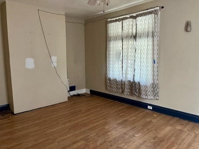 unfurnished room with ceiling fan and wood-type flooring