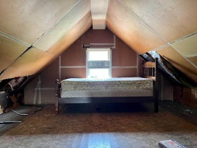 unfurnished bedroom with vaulted ceiling and cooling unit