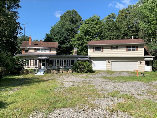 rear view of house with a lawn and a garage