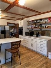 kitchen featuring light hardwood / wood-style floors, white cabinets, and black appliances