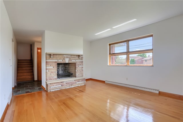 unfurnished living room with light hardwood / wood-style floors and a baseboard heating unit