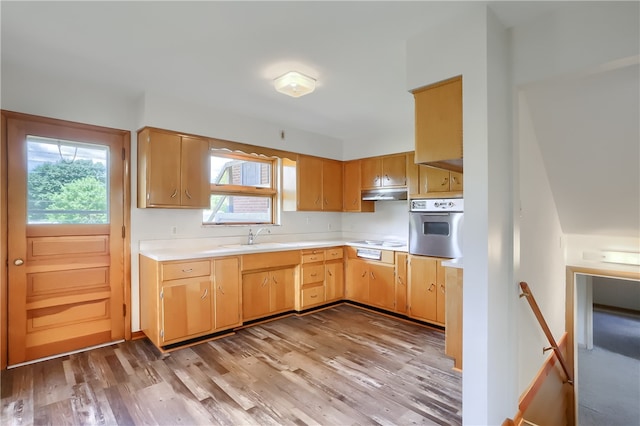 kitchen featuring light wood-type flooring, stainless steel oven, sink, and cooktop