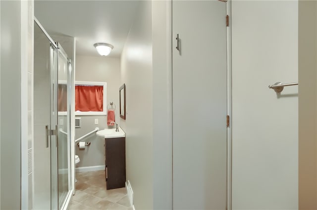 bathroom with an enclosed shower, toilet, vanity, and tile patterned floors