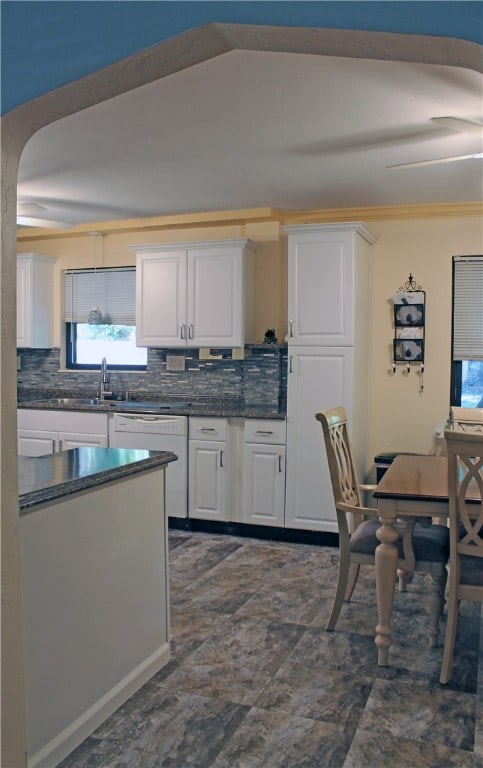 kitchen featuring white cabinetry, backsplash, sink, white dishwasher, and ceiling fan