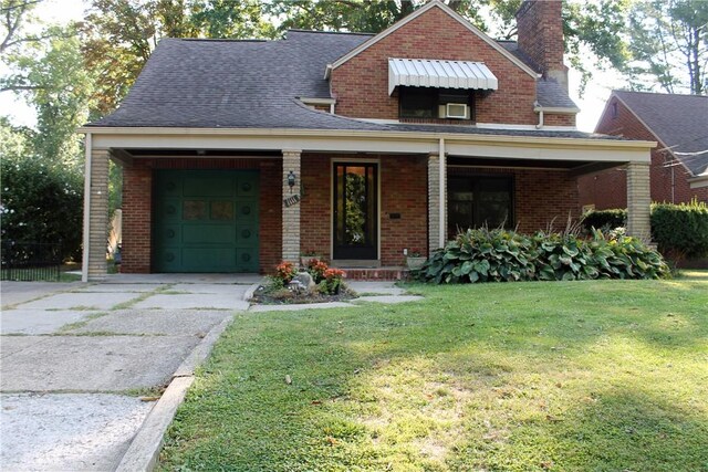 view of front of property with a garage, a front lawn, and a porch