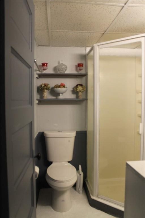 bathroom with a stall shower, a drop ceiling, vanity, and toilet