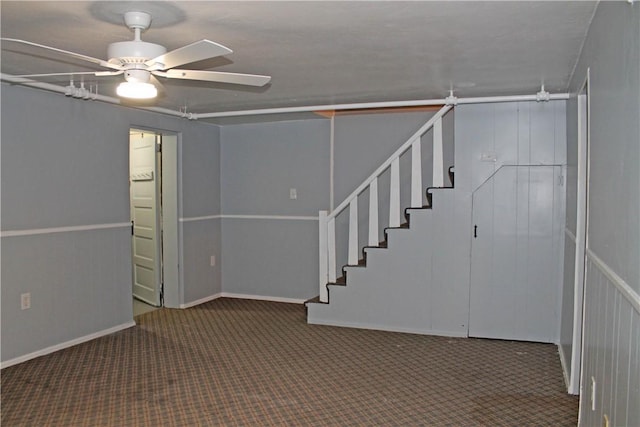 interior space with stairs, ceiling fan, and carpet