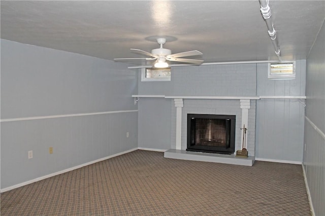 unfurnished living room with a fireplace, a ceiling fan, and carpet flooring