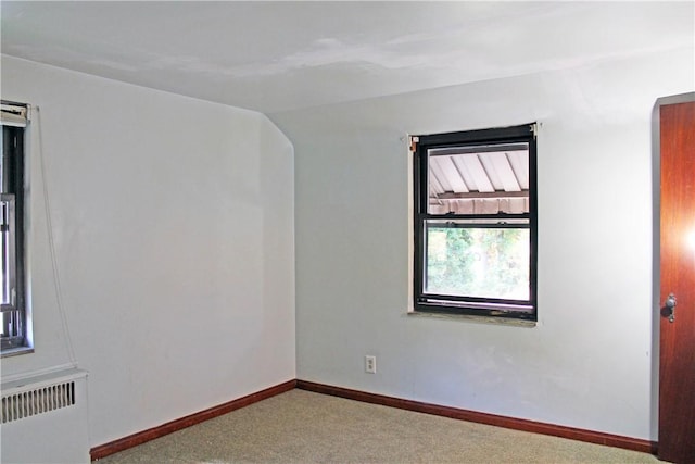 unfurnished room featuring radiator heating unit, carpet, and baseboards