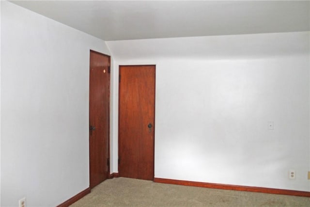 spare room featuring carpet floors and baseboards