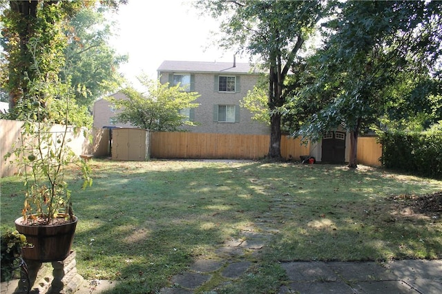 view of yard with an outbuilding, a storage unit, and a fenced backyard