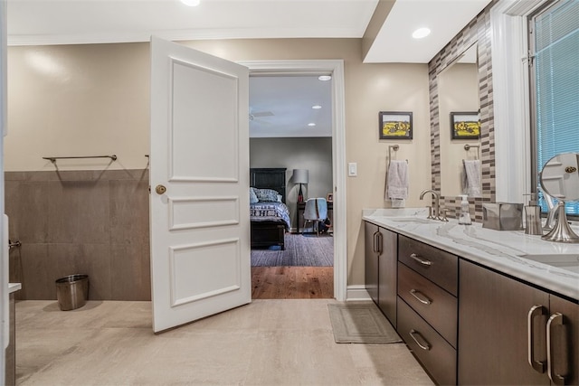 bathroom with tile walls, vanity, and tile patterned floors