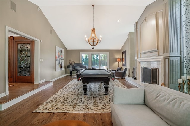 recreation room featuring a chandelier, high vaulted ceiling, wood-type flooring, billiards, and a premium fireplace