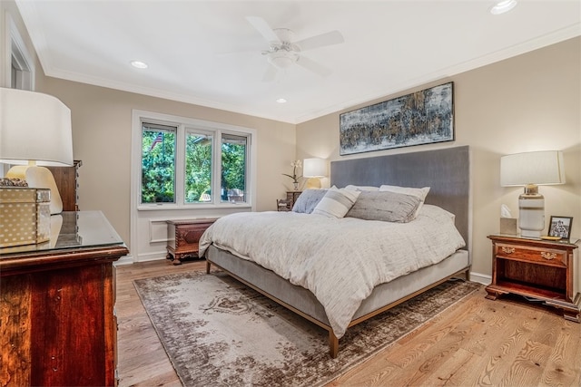 bedroom featuring ceiling fan, light hardwood / wood-style floors, and ornamental molding