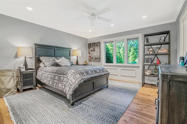 bedroom featuring light hardwood / wood-style flooring, ceiling fan, and ornamental molding