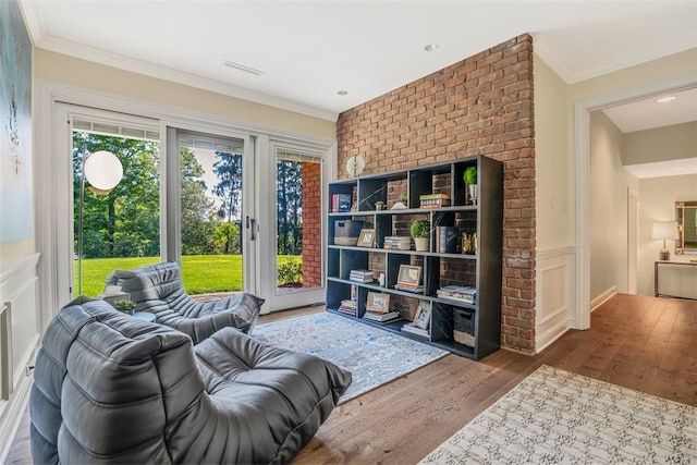 sitting room with a wealth of natural light, ornamental molding, and hardwood / wood-style flooring