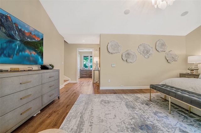 bedroom with light hardwood / wood-style floors and vaulted ceiling