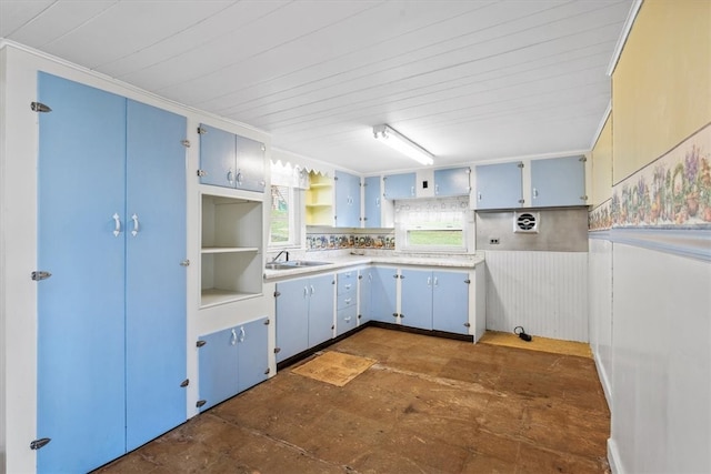 kitchen featuring sink, dark tile patterned floors, decorative backsplash, and blue cabinetry