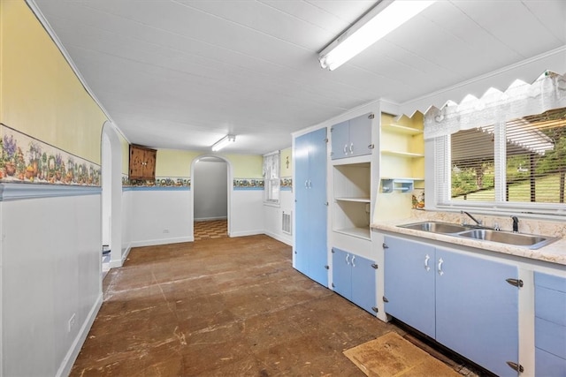 kitchen featuring sink, dark tile patterned floors, and blue cabinetry