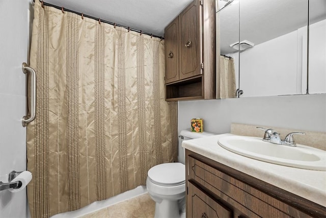 bathroom featuring tile patterned flooring, toilet, vanity, and walk in shower