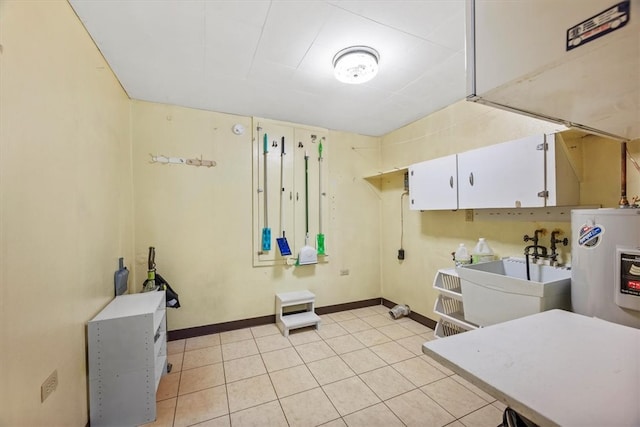 washroom featuring light tile patterned floors, sink, and water heater