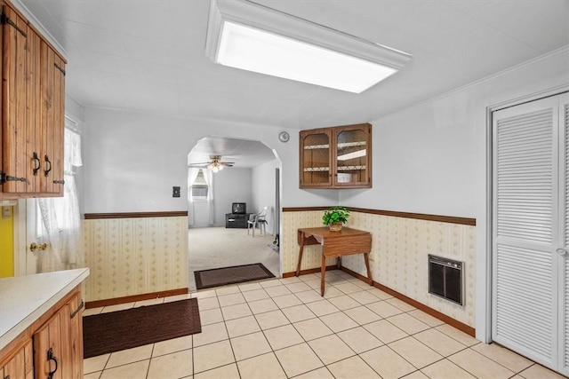 kitchen with ceiling fan, light carpet, and a fireplace