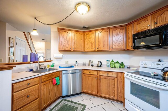 kitchen with stainless steel dishwasher, electric range, hanging light fixtures, sink, and light tile patterned flooring