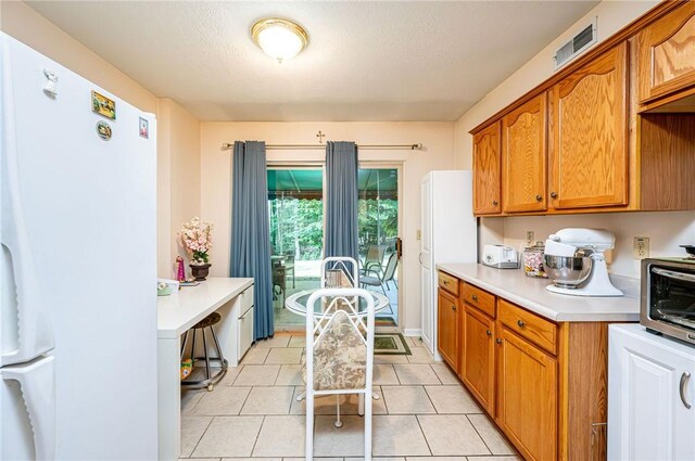 kitchen featuring white refrigerator and light tile patterned flooring