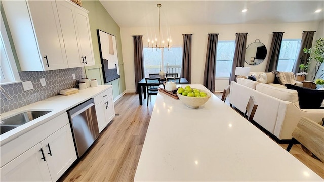 kitchen featuring dishwasher, light wood-type flooring, white cabinets, and hanging light fixtures