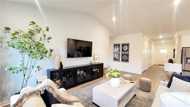 living room featuring vaulted ceiling and light wood-type flooring