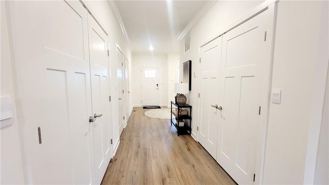 hall featuring ornamental molding and light wood-type flooring