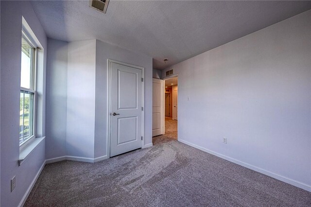 unfurnished bedroom with carpet and a textured ceiling