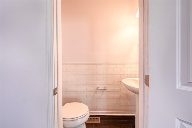 bathroom featuring tile walls, sink, and toilet