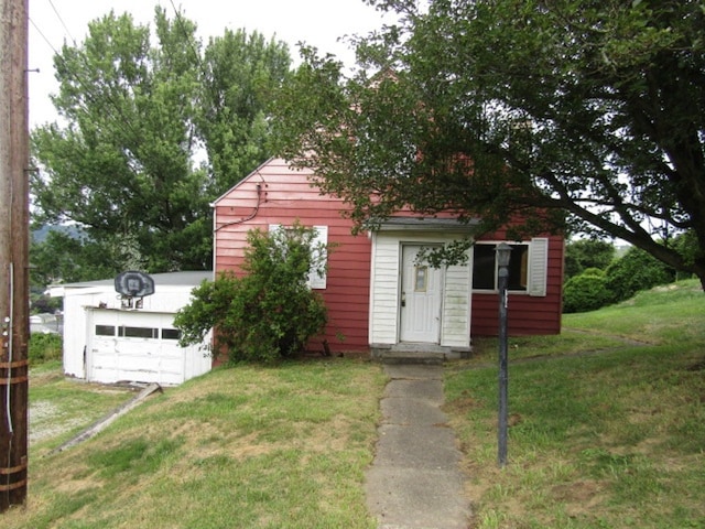 exterior space with a garage and a lawn