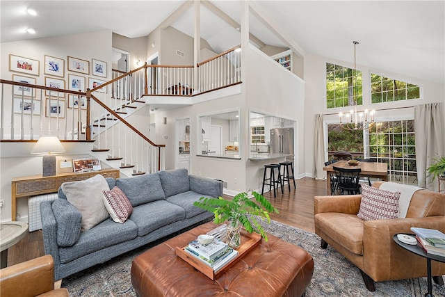 living room featuring wood-type flooring, an inviting chandelier, and high vaulted ceiling