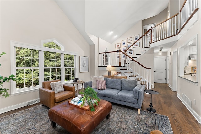 living room with dark hardwood / wood-style flooring and high vaulted ceiling