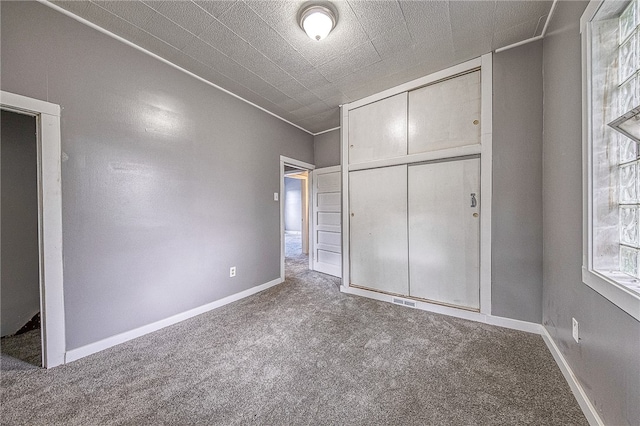 unfurnished bedroom with a closet and carpet flooring